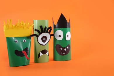 Photo of Funny monsters on orange background. Halloween decoration
