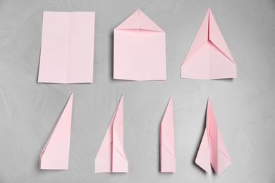 Photo of Instruction for making paper plane step by step on light grey table, flat lay