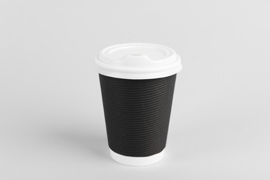 Photo of Black paper cup with plastic lid on light background. Coffee to go