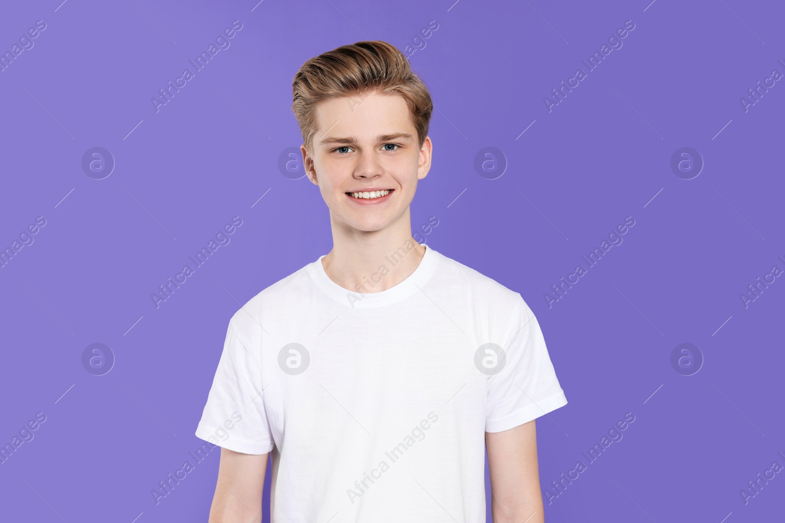 Photo of Portrait of teenage boy on purple background