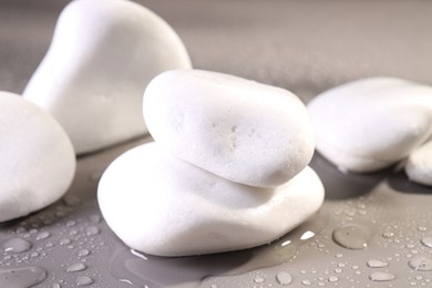 Photo of White spa stones with water drops on grey background