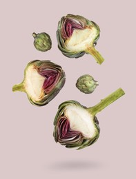 Image of Fresh raw artichokes falling on light grey background