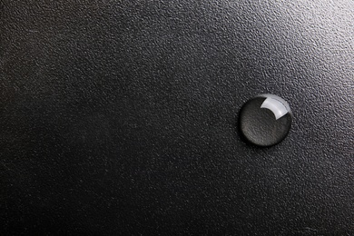 Photo of Water drop on black background, top view