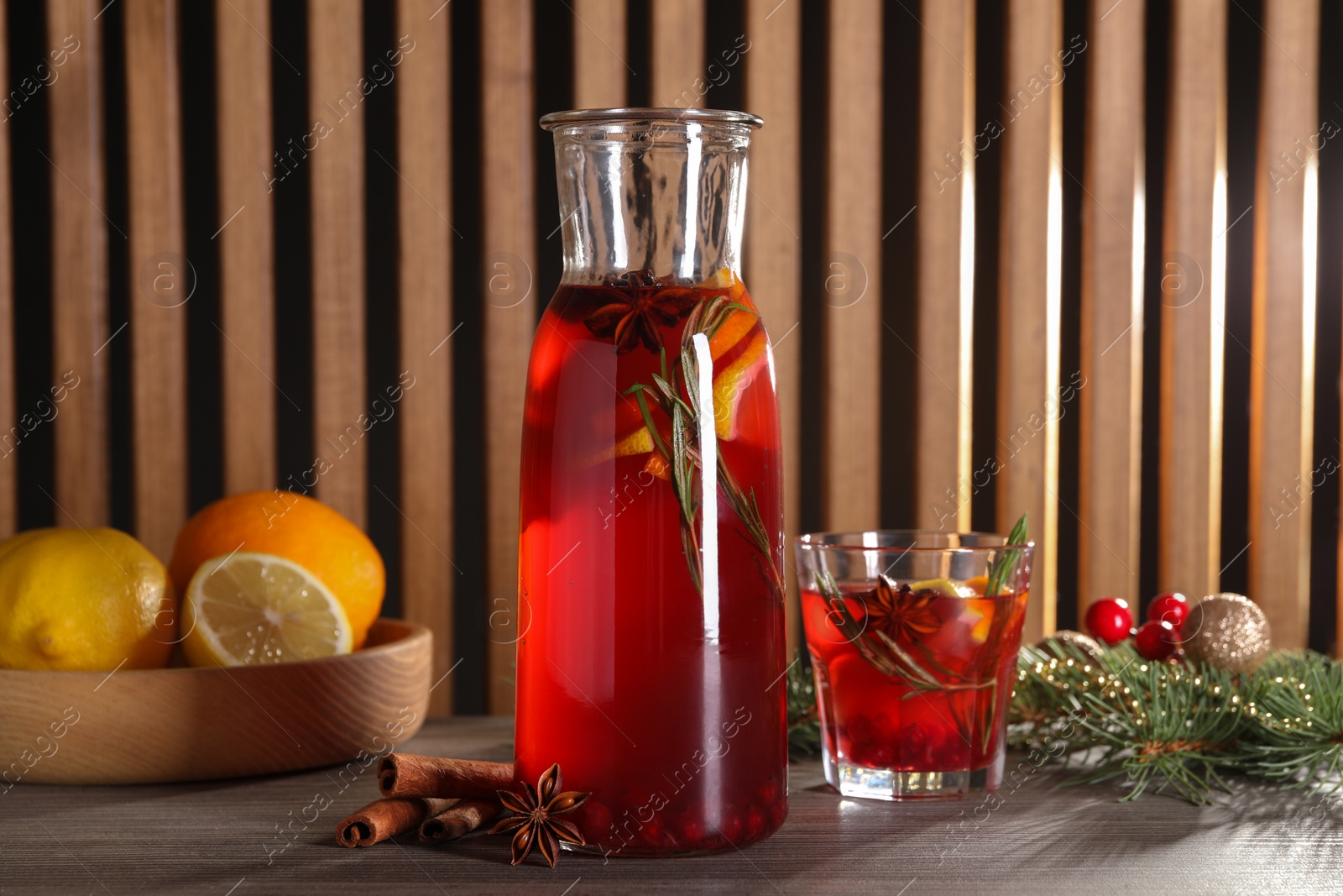 Photo of Aromatic punch drink, ingredients and Christmas decor on wooden table