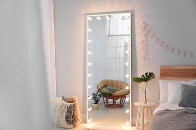 Photo of Large mirror with light bulbs in stylish room interior