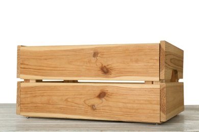 Empty rustic wooden crate on table against white background