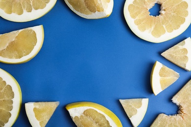 Photo of Frame made of delicious ripe pomelo slices on blue background, flat lay. Space for text