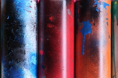 Photo of Different spray paint cans as background, top view