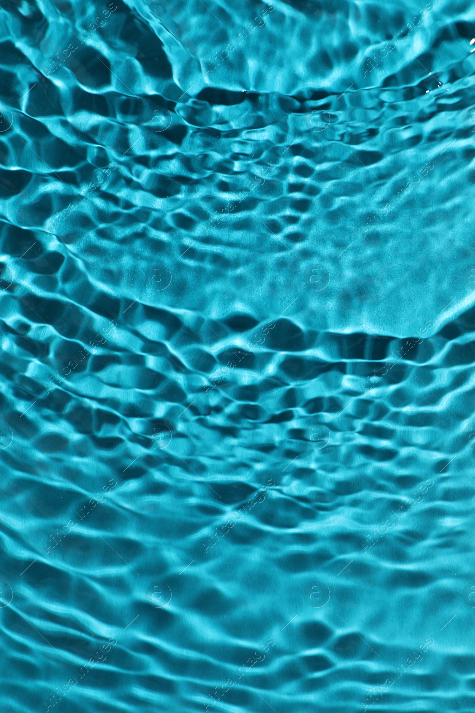 Photo of Rippled surface of clear water on light blue background, top view