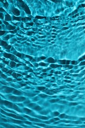 Rippled surface of clear water on light blue background, top view