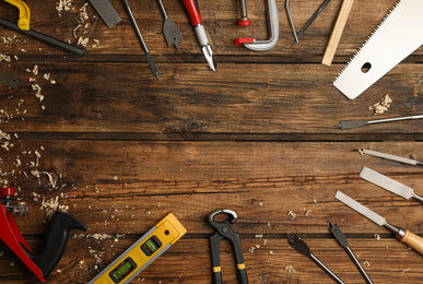 Photo of Frame made with carpenter's tools on wooden background, flat lay. Space for text