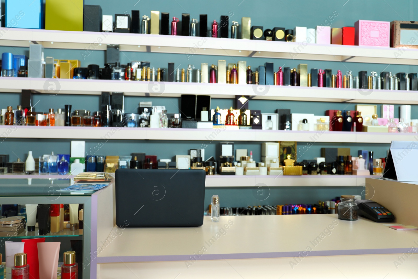 Image of Counter and shelves with perfume bottles in shop