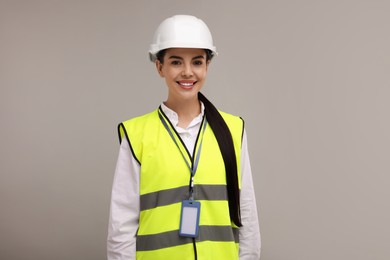 Photo of Engineer with hard hat and badge on grey background