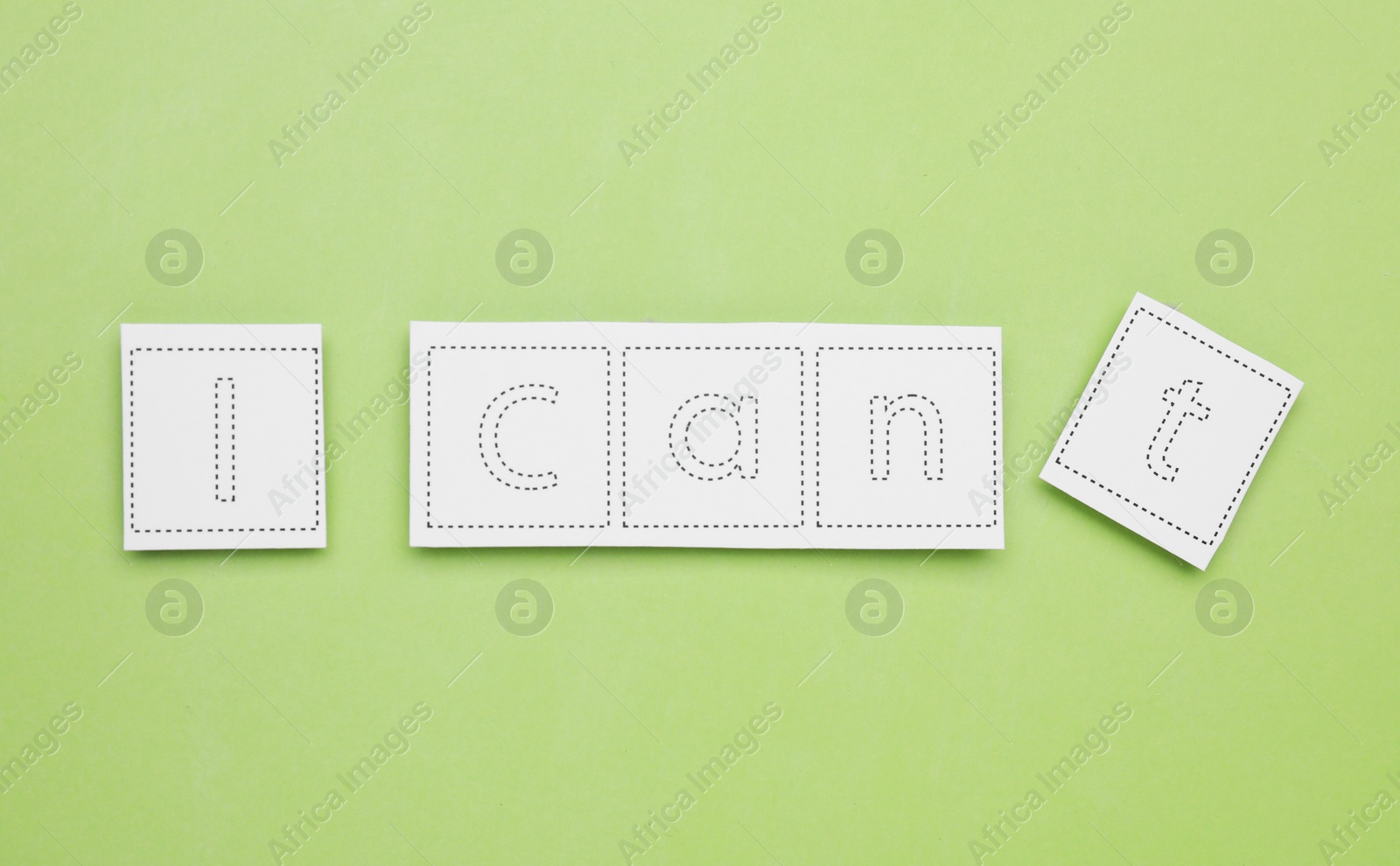 Photo of Motivation concept. Changing phrase from I Can't into I Can by removing paper with letter T on light green background, flat lay