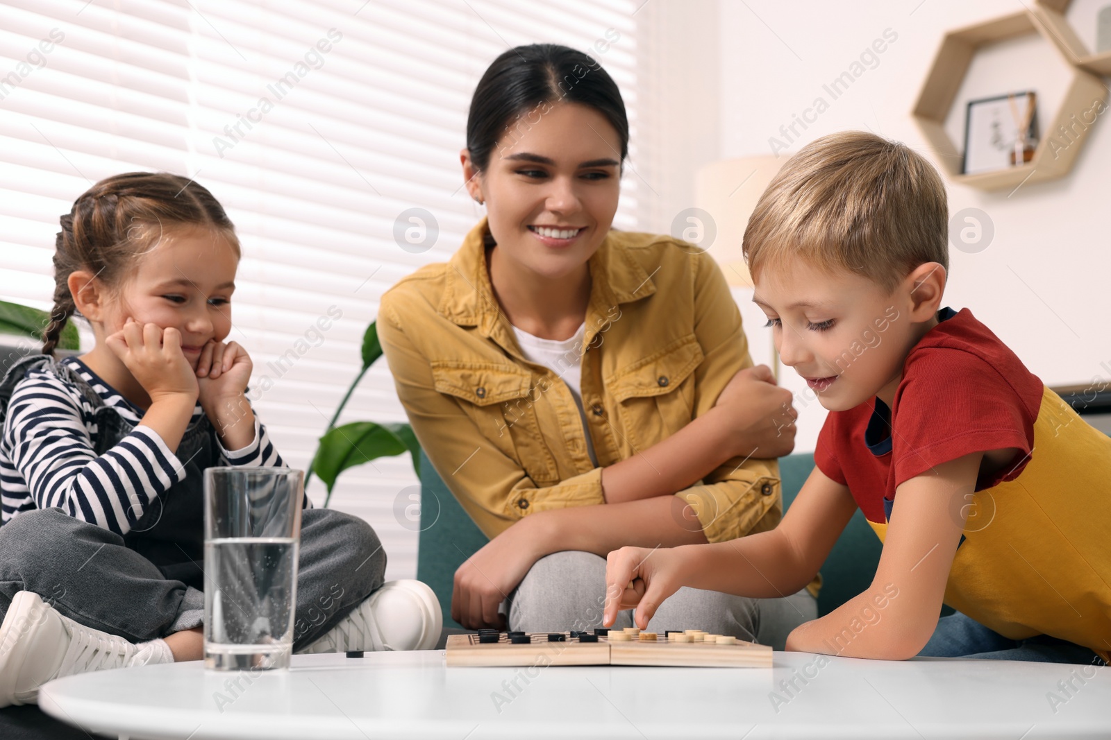 Photo of Family playing checkers at coffee table in room