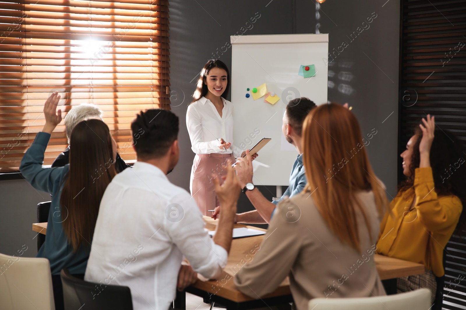 Photo of Business trainer answering questions at seminar in conference hall