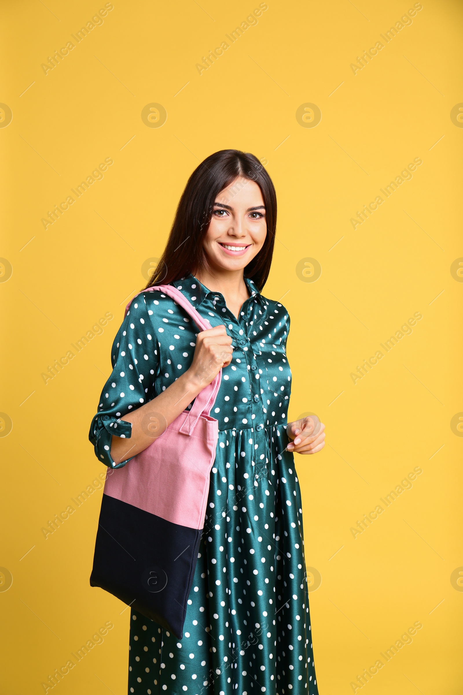 Photo of Portrait of young woman with textile bag on yellow background