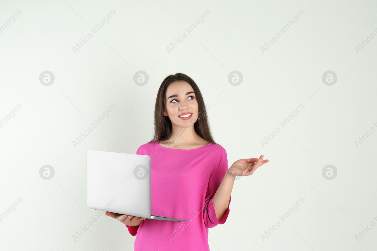 Photo of Portrait of young woman in casual outfit with laptop on light background