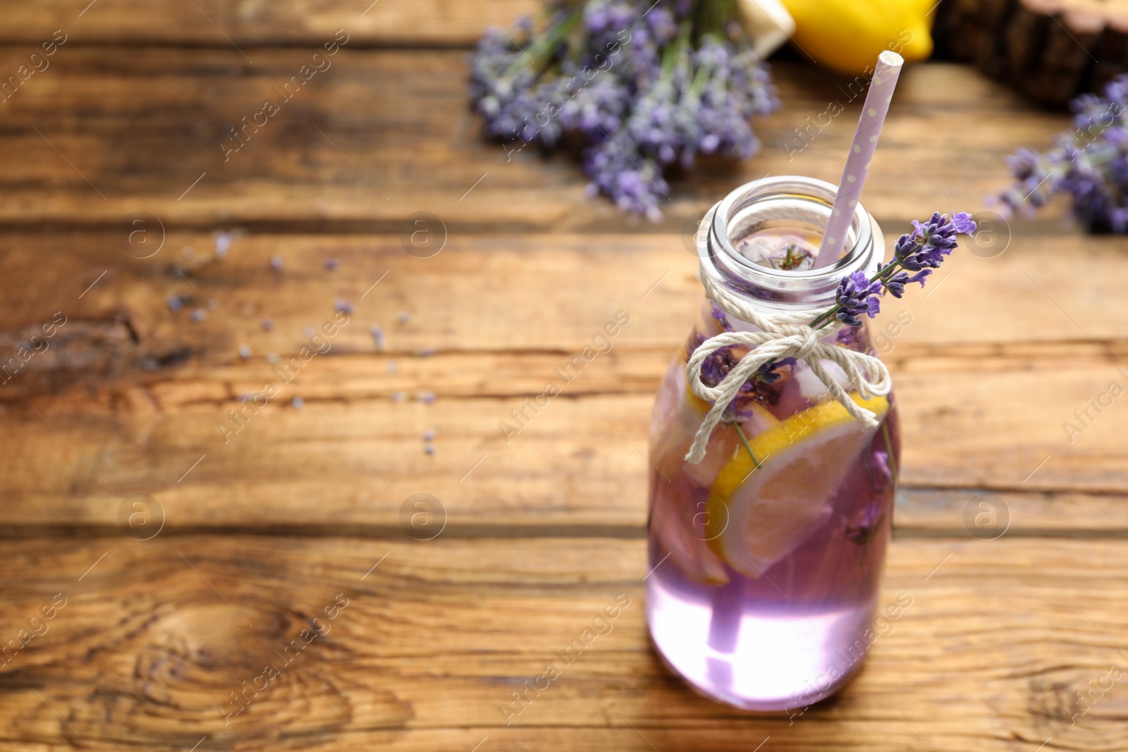 Photo of Fresh delicious lemonade with lavender on wooden table. Space for text