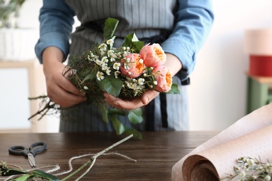 Photo of Female florist creating beautiful bouquet at table