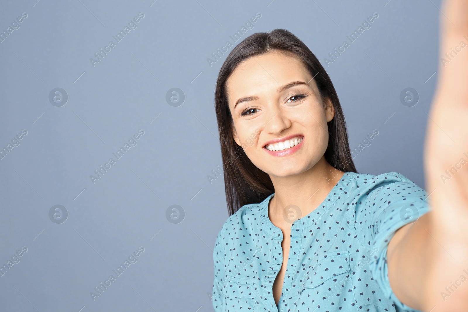 Photo of Young beautiful woman taking selfie against grey background