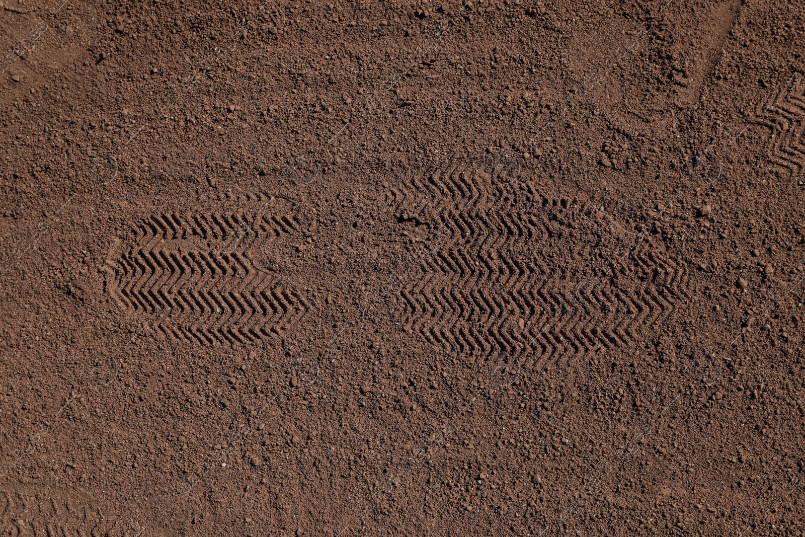 Photo of Textured ground surface with footprint, top view