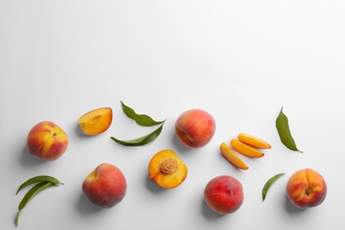 Composition with fresh peaches on white background, top view