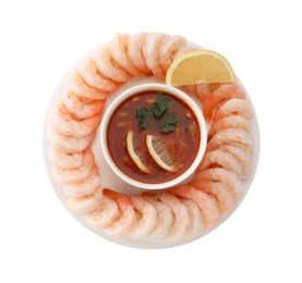 Tasty boiled shrimps with cocktail sauce and lemon isolated on white, top view