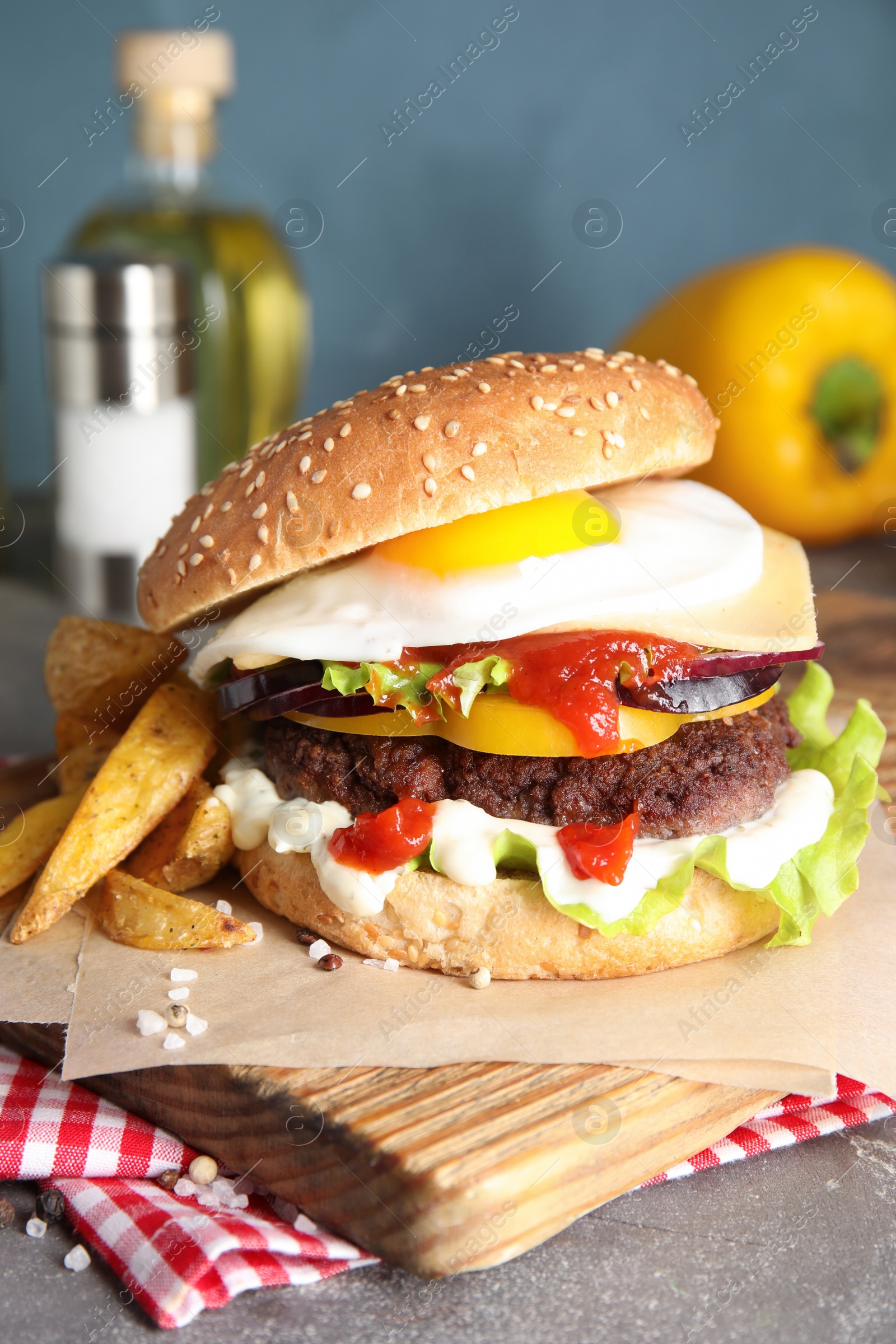 Photo of Tasty burger with fried egg on wooden board