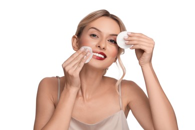 Photo of Smiling woman removing makeup with cotton pads on white background