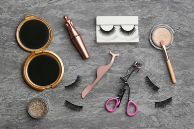 Flat lay composition with magnetic eyelashes and accessories on grey table