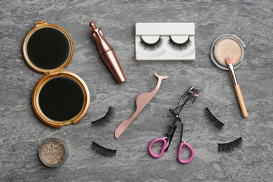 Photo of Flat lay composition with magnetic eyelashes and accessories on grey table