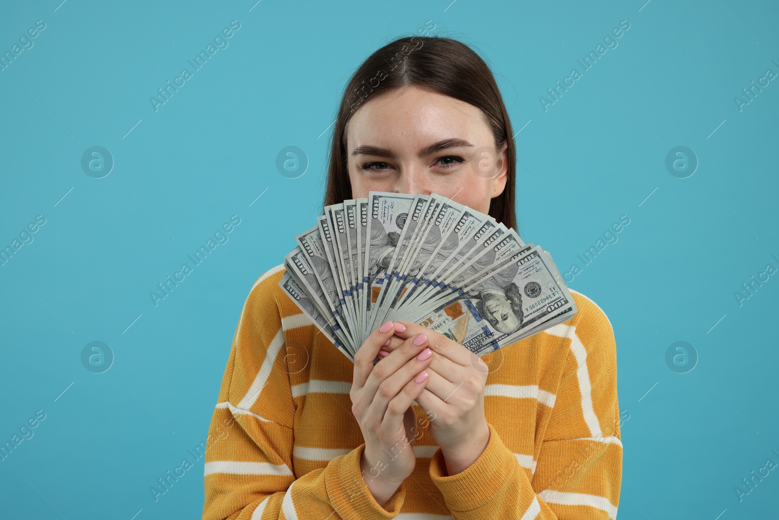 Photo of Woman with dollar banknotes on light blue background