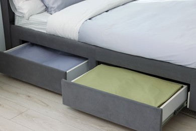 Storage drawers with bedding under modern bed in room