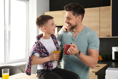 Dad and son having breakfast together in kitchen