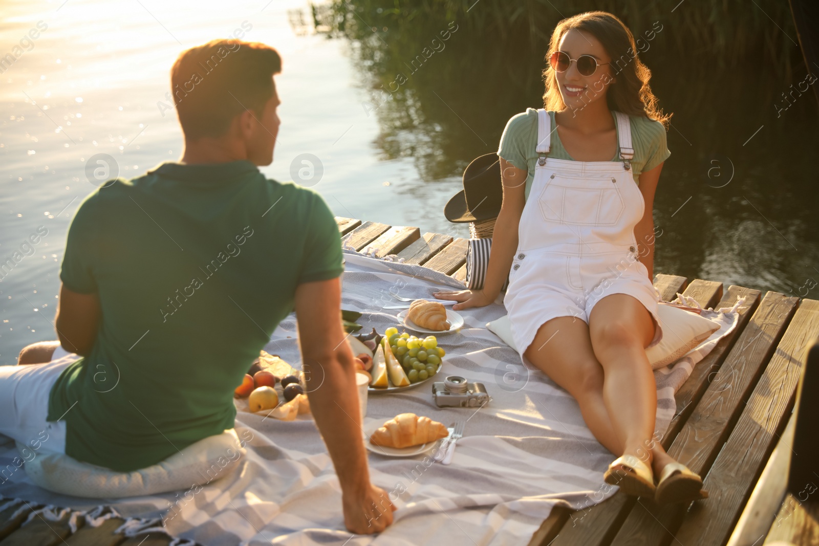 Photo of Happy couple spending time on pier at picnic