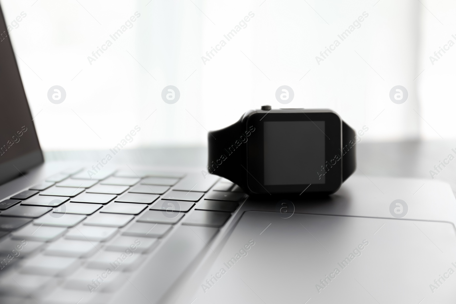 Modern stylish smart watch on laptop, closeup Photo of Modern stylish smart watch on laptop, closeup