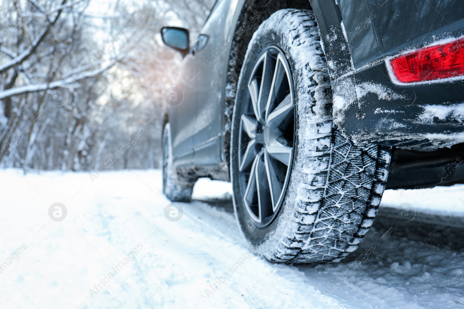 Photo of Snowy country road with car on winter day, closeup. Space for text