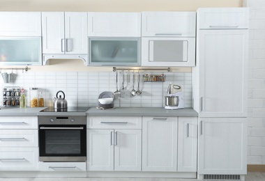 Photo of Stylish kitchen interior with modern refrigerator and furniture