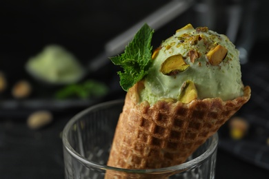 Photo of Delicious pistachio ice cream on dark background, closeup. Space for text