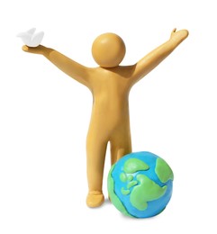 Photo of Yellow plasticine human figure with dove and planet isolated on white