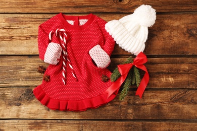 Flat lay composition with cute Christmas baby clothes on wooden background