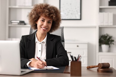 Notary with clipboard writing notes at workplace in office