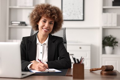 Photo of Notary with clipboard writing notes at workplace in office