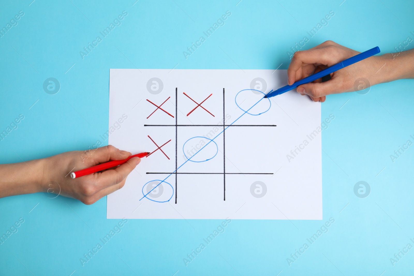 Photo of Women playing tic-tac-toe on color background, top view. Victory concept