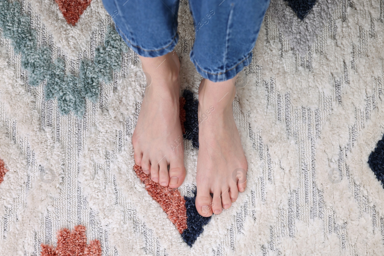 Photo of Woman on carpet with pattern at home, top view