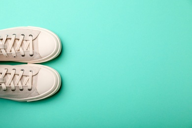 Pair of stylish sneakers on color background, top view