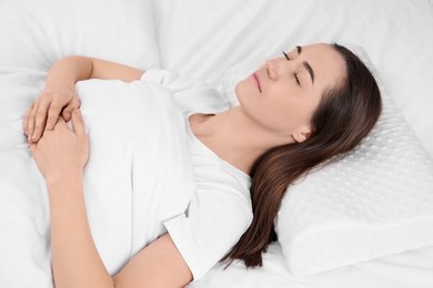 Photo of Woman sleeping on orthopedic pillow in bed