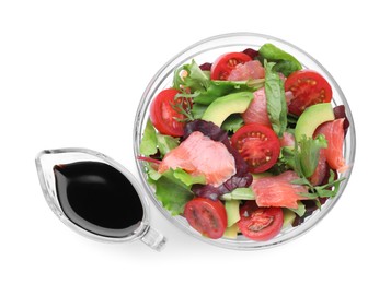 Photo of Tasty soy sauce and bowl with salad isolated on white, top view