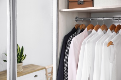 Photo of Wardrobe closet with different stylish clothes in room, closeup